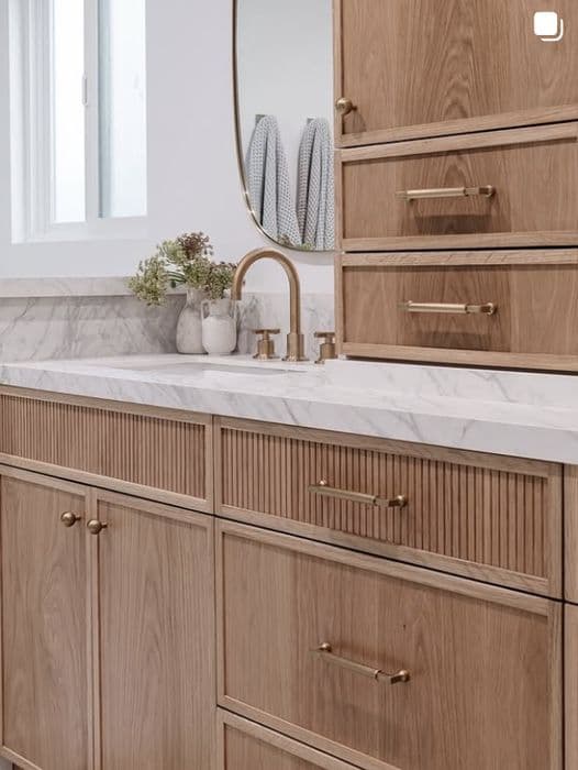 Fluted white oak bathroom vanity with brass hardware